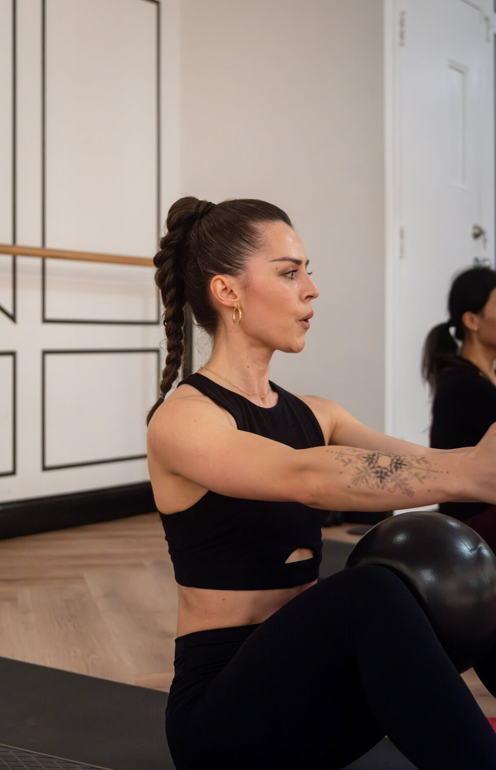 Barre Belle member doing a seated Pilates-inspired exercise in class